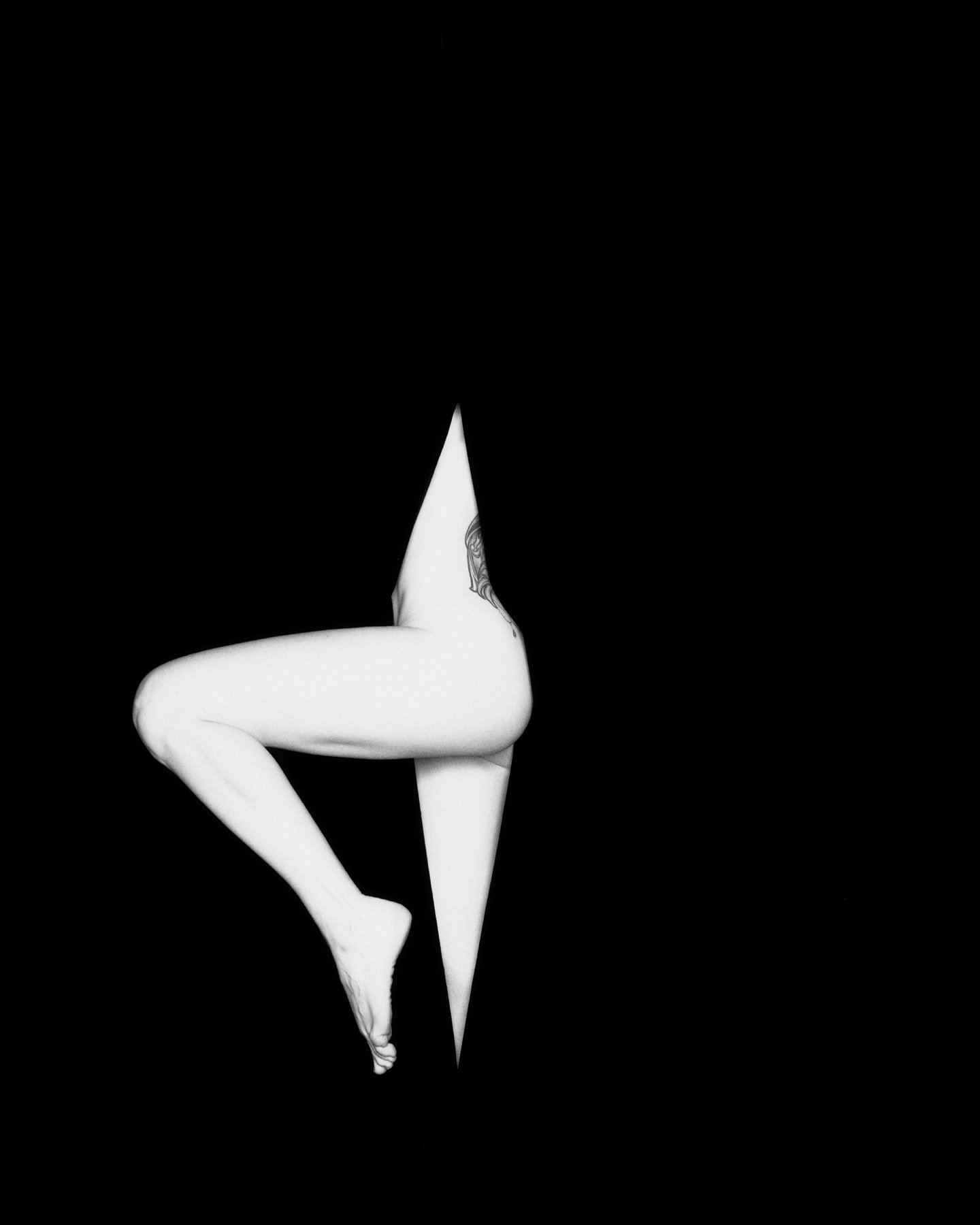 Compass — high-contrast figure forming a geometric shape against darkness, Void series, fine art photography print by Kofi Amoa